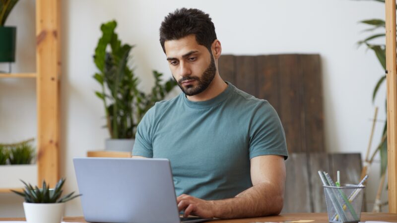 Bearded Man using laptop at Home Office