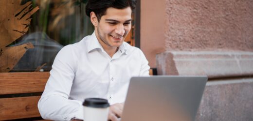 in a cafe uses a laptop writes a message to the mail a manager in an official suit