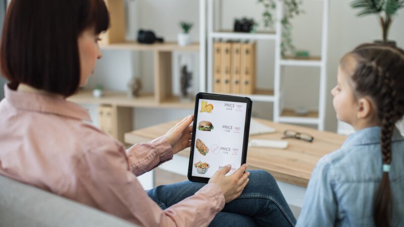Ladies checking discounts on food delivery online website