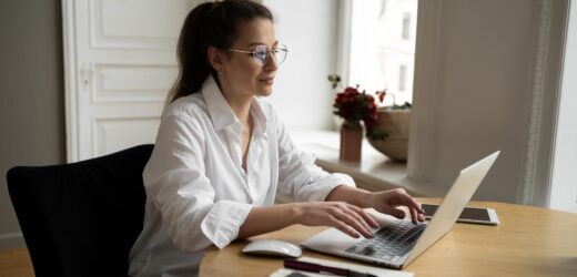 Manager woman with glasses works in the office writes a message to the client on the post