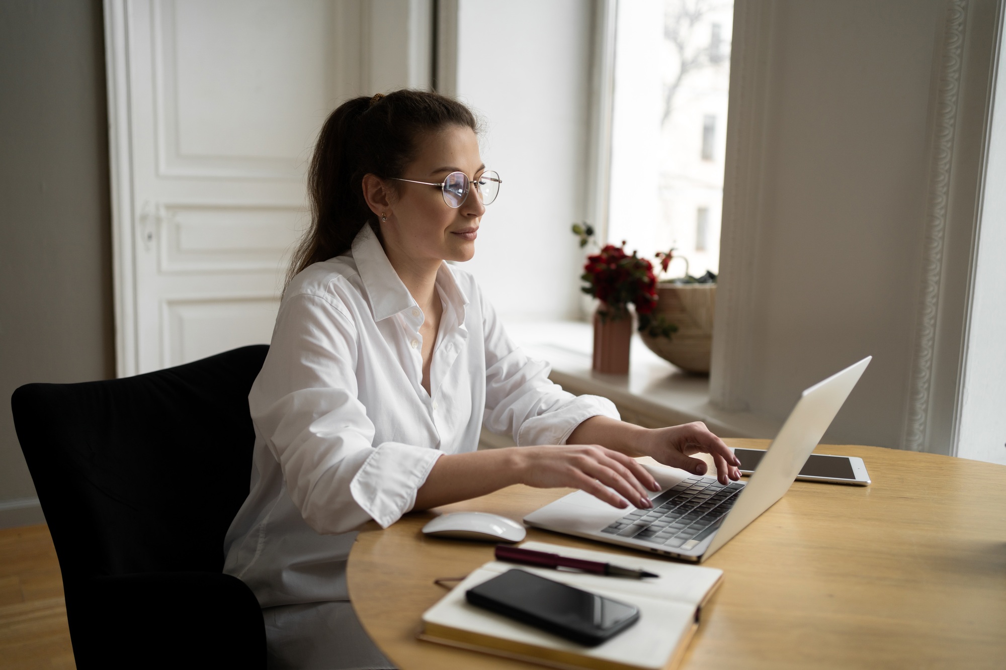 Manager woman with glasses works in the office writes a message to the client on the post