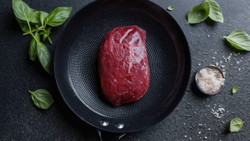 Raw meat with spices and herbs on table