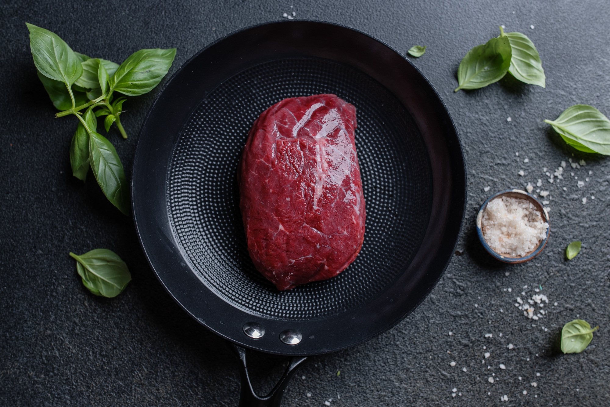 Raw meat with spices and herbs on table