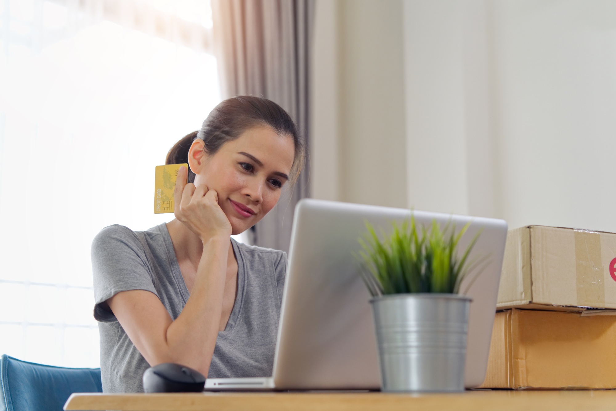 Asian beautiful girl buying online from website using credit card for payment.