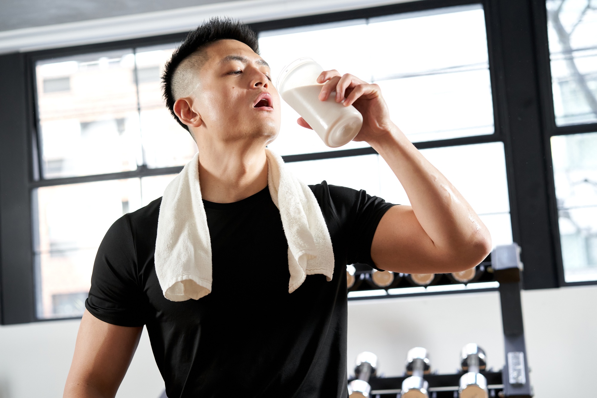 Asian men drinking protein after training