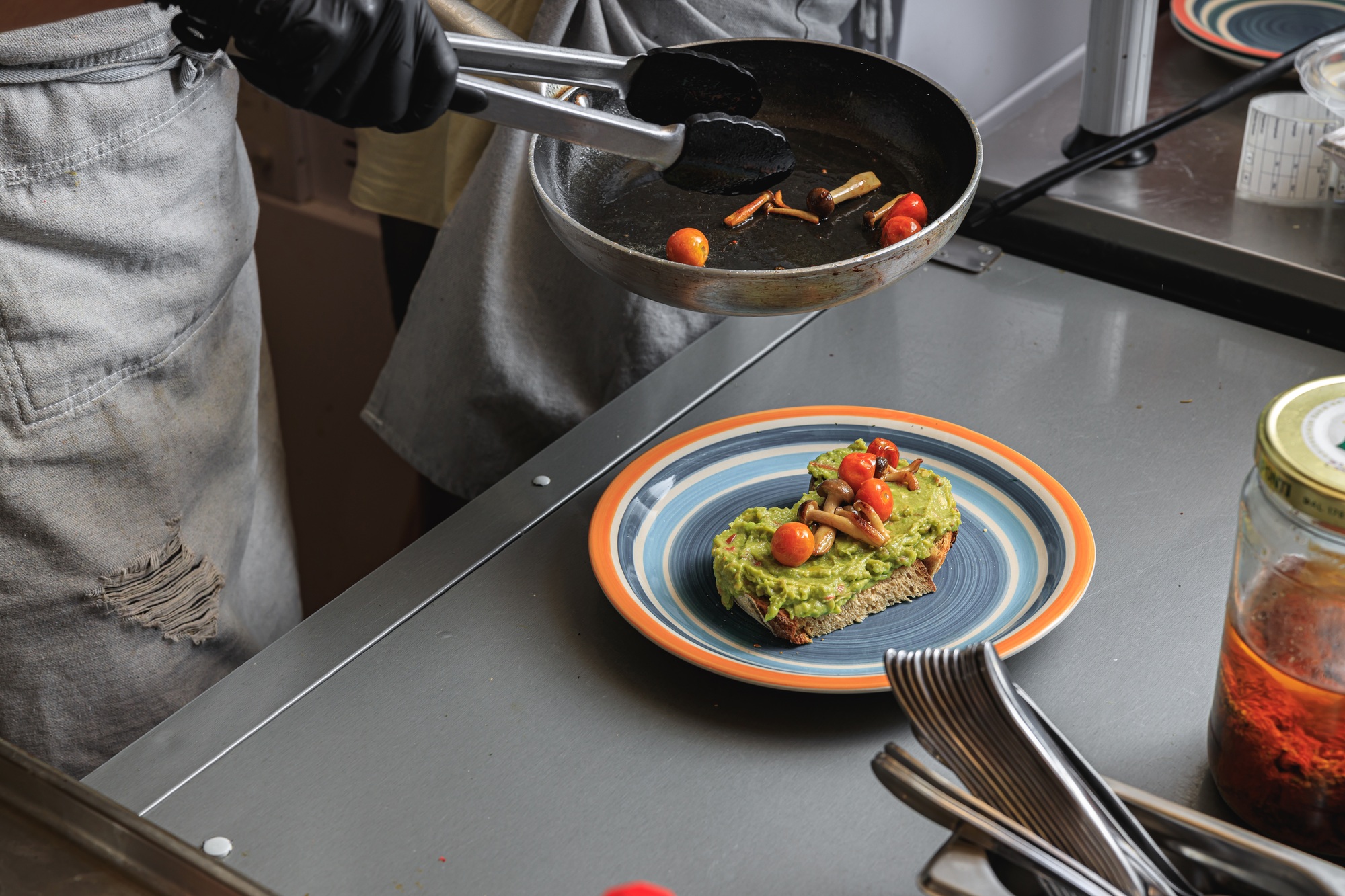 Chef hands cooking avocado toast with vegetables for breakfast menu in restaurant kitchen