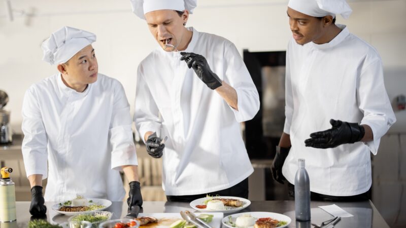 Cooks with different nationalties tasting cooked meals for restaurant menu