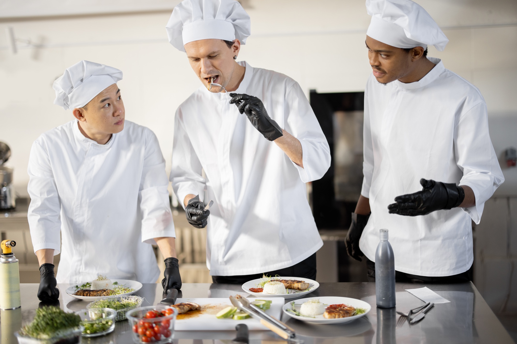 Cooks with different nationalties tasting cooked meals for restaurant menu