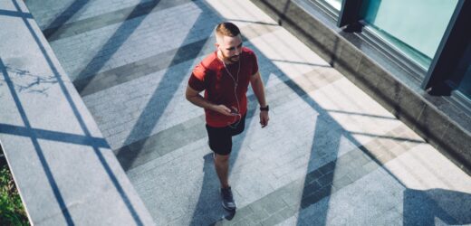 Man in earphones walking on street
