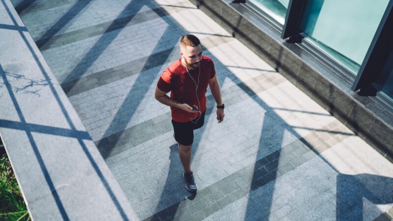 Man in earphones walking on street