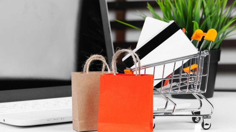 Online shopping concept. Shopping cart, laptop on the desk