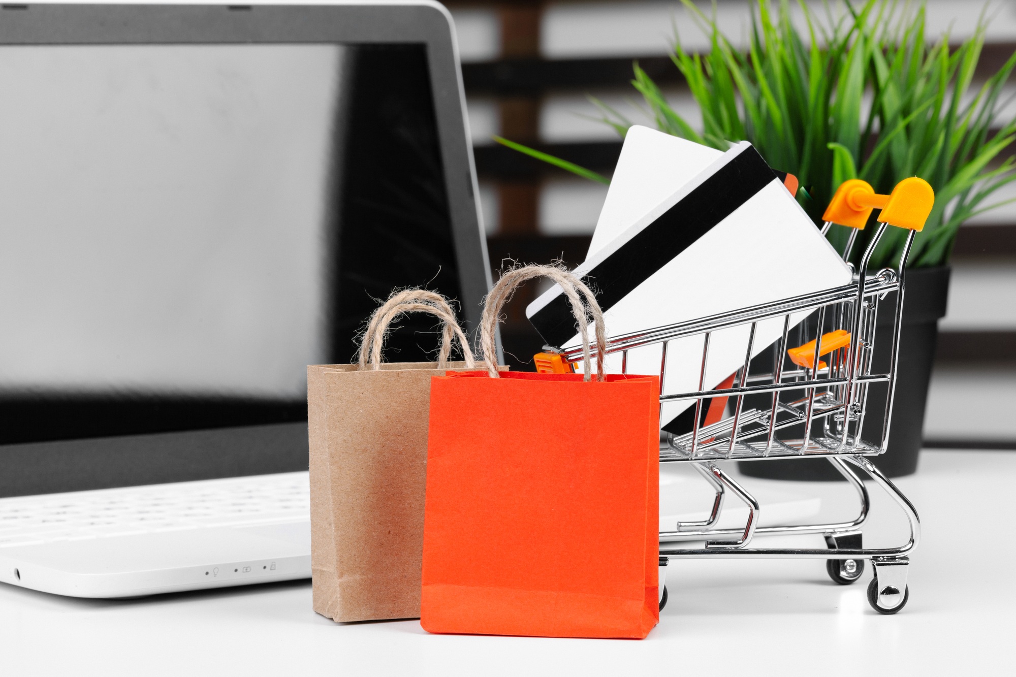 Online shopping concept. Shopping cart, laptop on the desk
