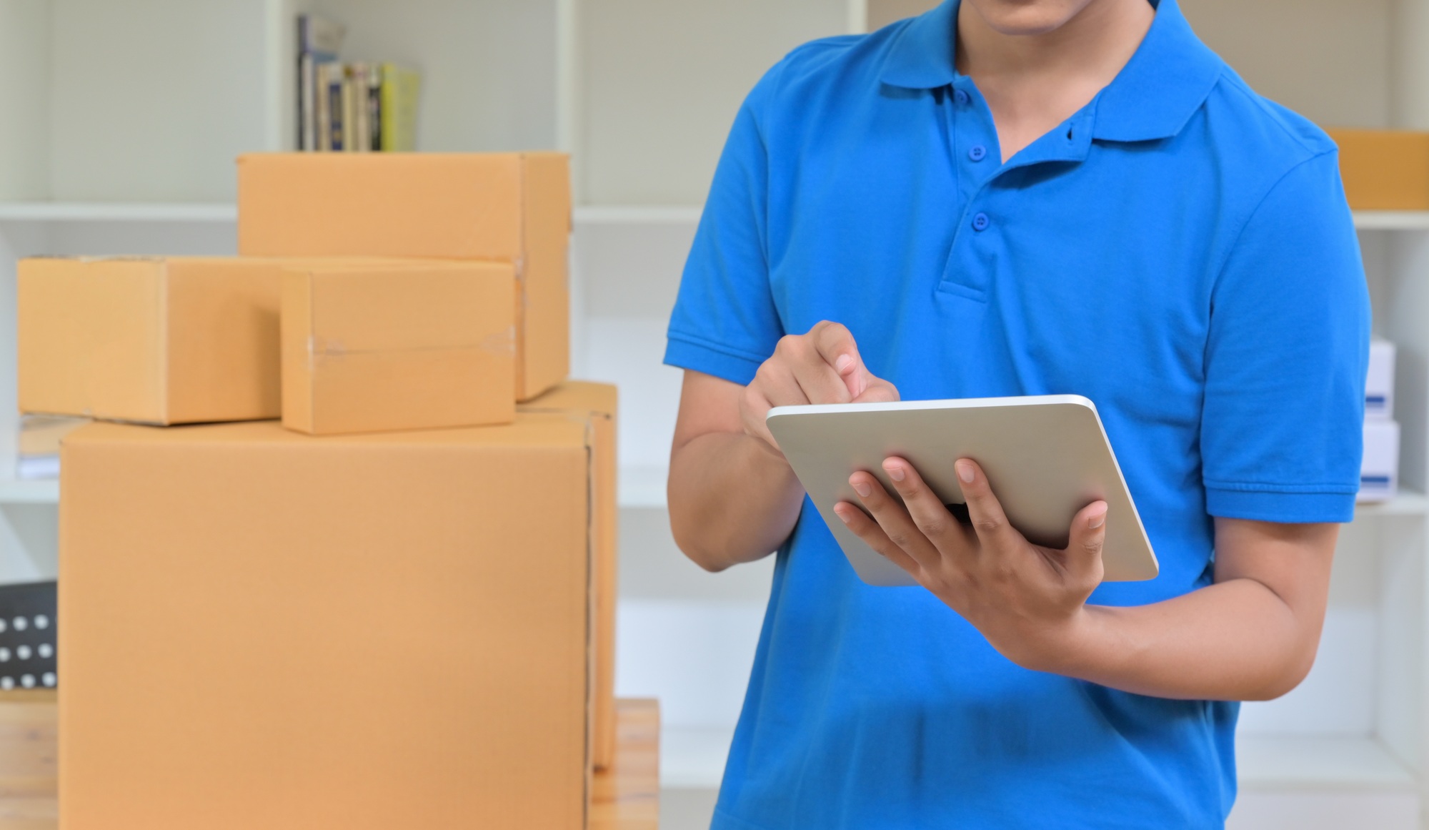 The courier is using a tablet to record the delivery information.