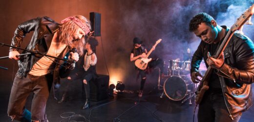 Young rock and roll band playing hard rock music on stage
