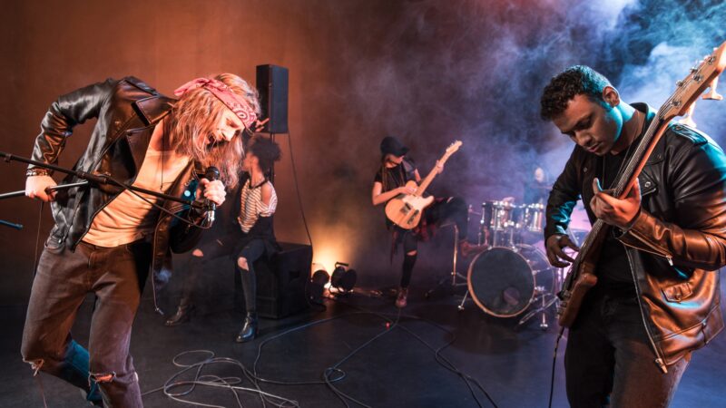 Young rock and roll band playing hard rock music on stage