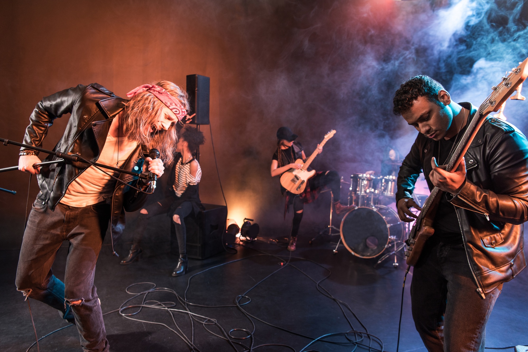 Young rock and roll band playing hard rock music on stage