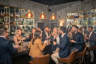 Groupe d'adultes élégants en pleine soirée dans un club branché de Lille, ambiance conviviale et moderne au bar
